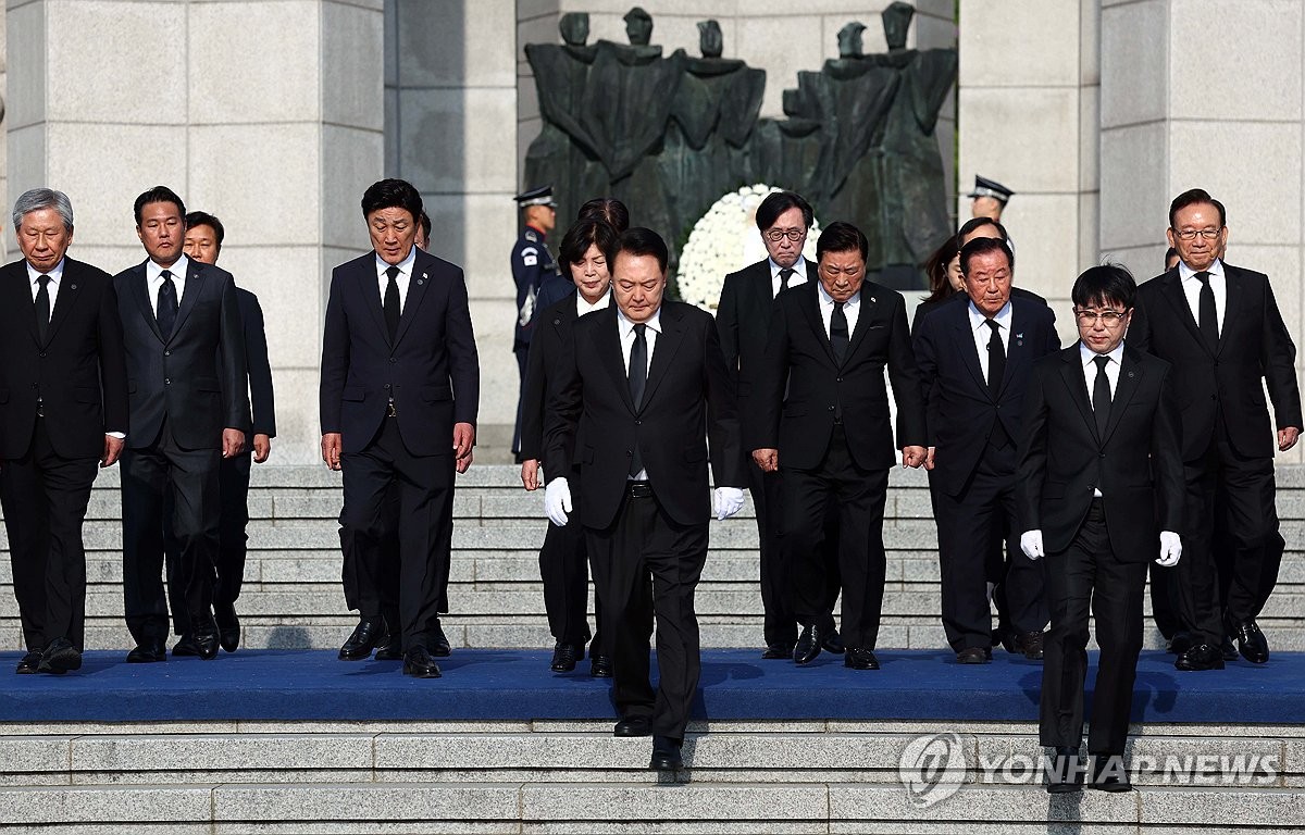 4月19日，在首尔江北区的国立四一九民主公墓，韩国总统尹锡悦（居中）向革命先烈焚香献花后离场。 韩联社/总统室通讯摄影记者团