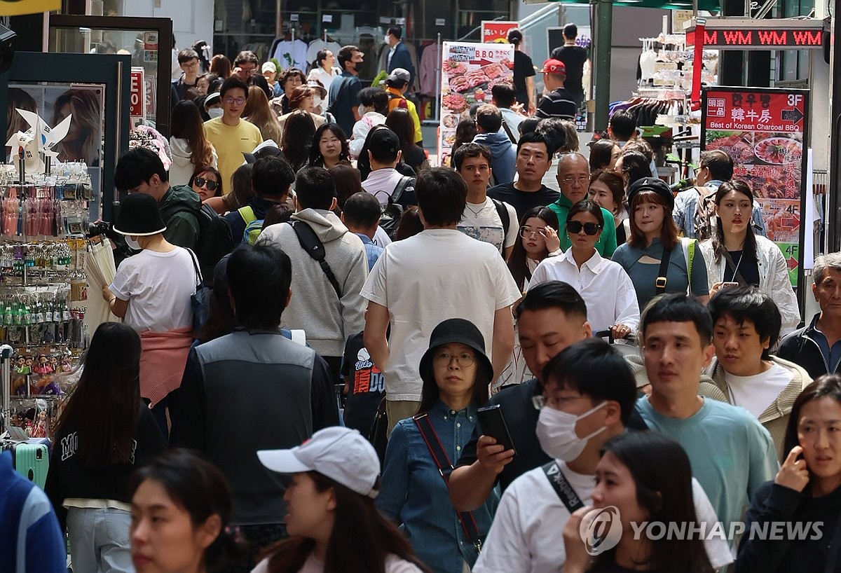 资料图片：首尔明洞一条商业步行街上游客如织。 韩联社