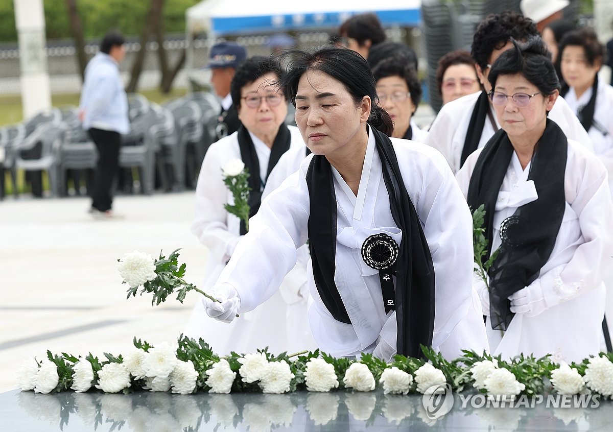 资料图片：5月17日，在光州市北区的国立五一八民主墓园，五一八民主化运动遇难者的家属向祭坛献花。 韩联社