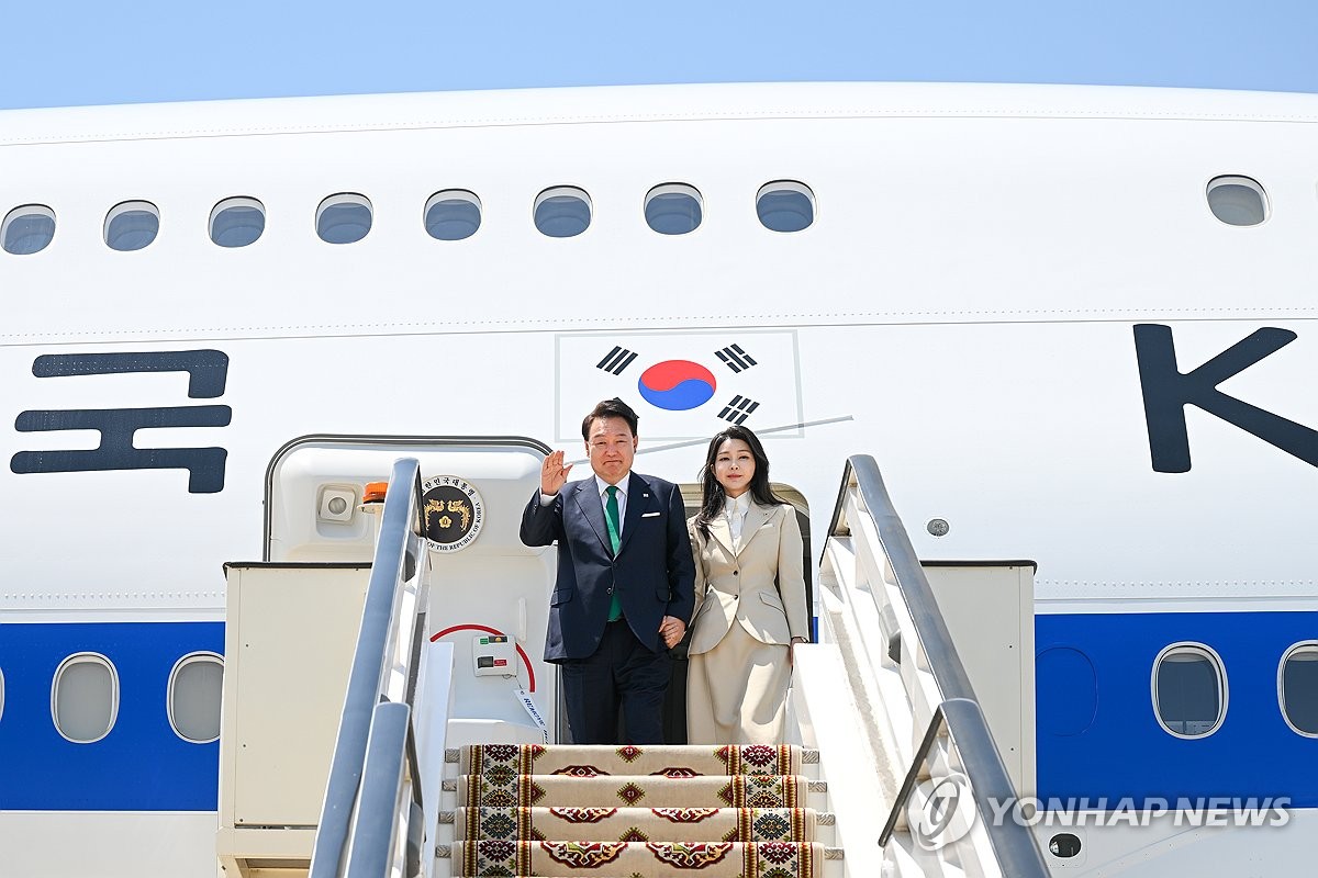 当地时间6月10日，韩国总统尹锡悦（左）和夫人金建希飞抵阿什哈巴德机场。 韩联社/联合采访团