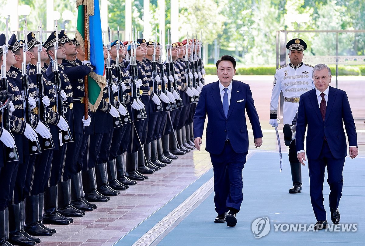 当地时间6月14日，在乌兹别克斯坦塔什干总统府迎宾馆，韩国总统尹锡悦（左）在乌兹别克斯坦总统沙夫卡特·米尔济约耶夫的陪同下检阅仪仗队。 韩联社