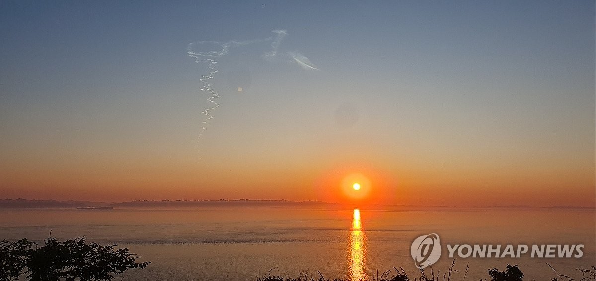 6月26日，在韩国西部海域白翎岛，居民向东方向眺望时发现高空中出现了一道弯弯曲曲的白烟。这道白烟疑似由朝鲜当天发射的导弹留下。朝鲜当天向东部海域发射型号不明的弹道导弹，韩国联合参谋本部称其发射疑遭失败。 韩联社/读者供图（图片严禁转载复制）