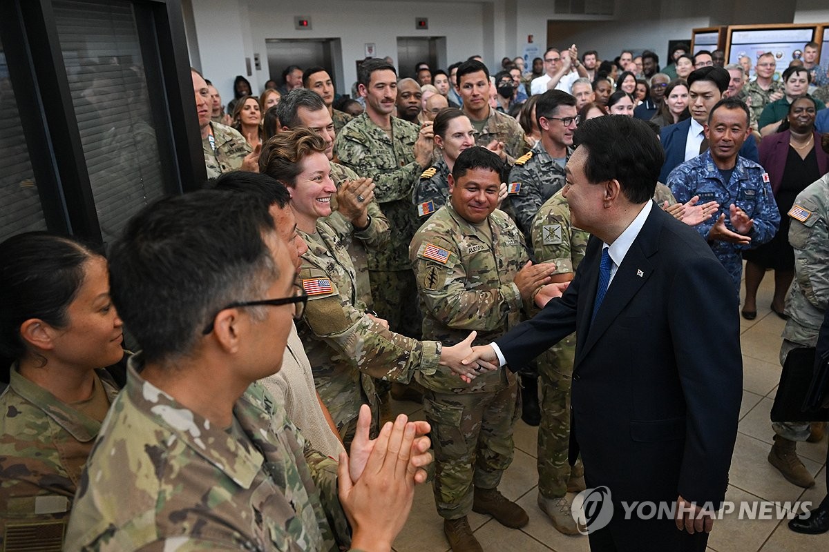 资料图片：当地时间7月9日，韩国总统尹锡悦访问位于夏威夷的美国印度太平洋司令部并勉励官兵。图为尹锡悦（右）与美军官兵握手致意。 韩联社/联合记者团