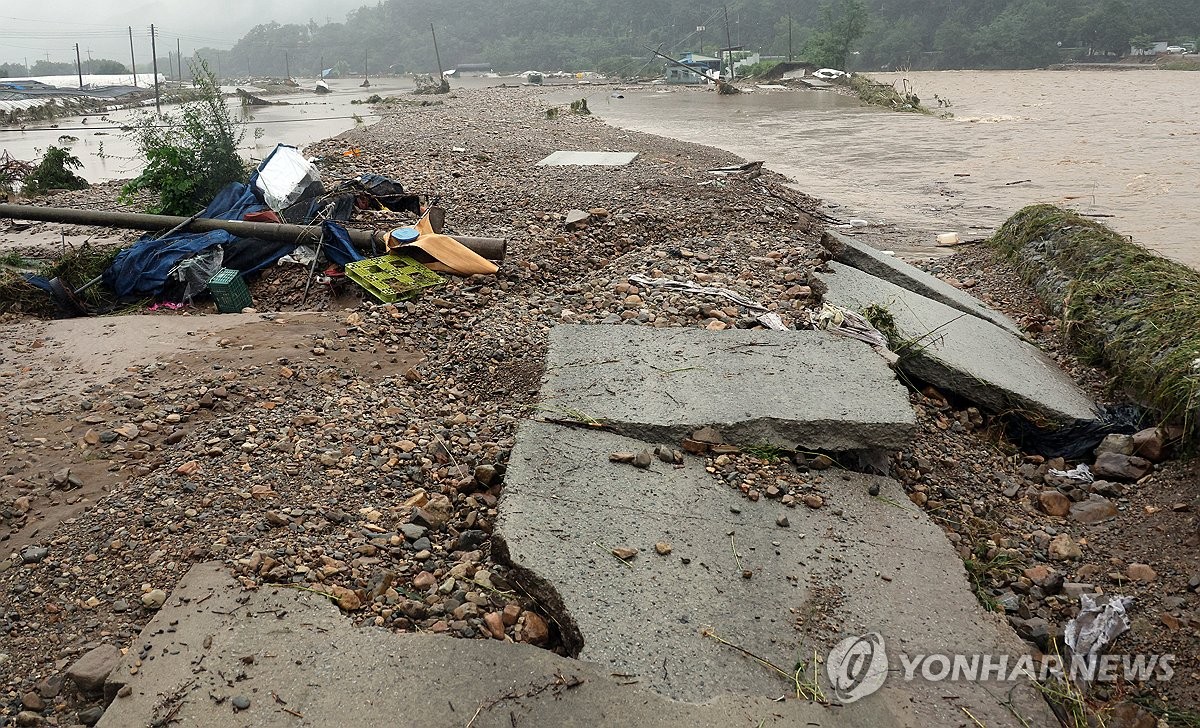 7月10日，位于全罗北道完州郡云洲面的长仙川（右）堤坝倒塌，导致道路中断，附近一带被水淹没。 韩联社