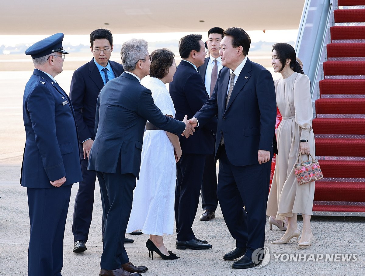 当地时间7月10日，在位于华盛顿特区附近的安德鲁斯空军基地，韩国总统尹锡悦（右二）下机后与接机人员握手致意。 韩联社