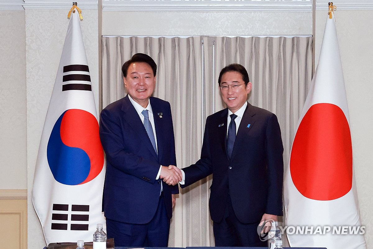 资料图片：当地时间7月10日，在美国华盛顿，韩国总统尹锡悦（左）同日本首相岸田文雄在举行会谈前合影留念。 韩联社