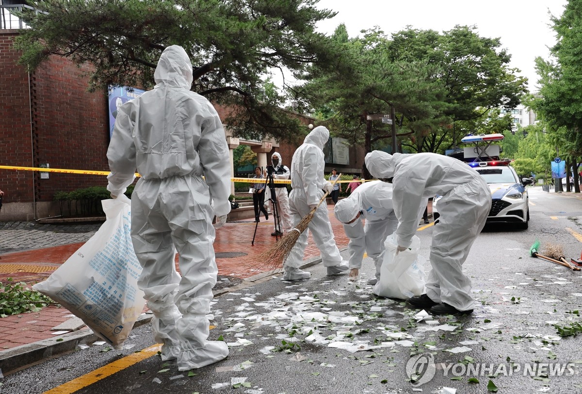 资料图片：7月24日，朝鲜空投的“垃圾气球”落在首尔中区国立贞洞剧场附近。图为工作人员清理垃圾。 韩联社