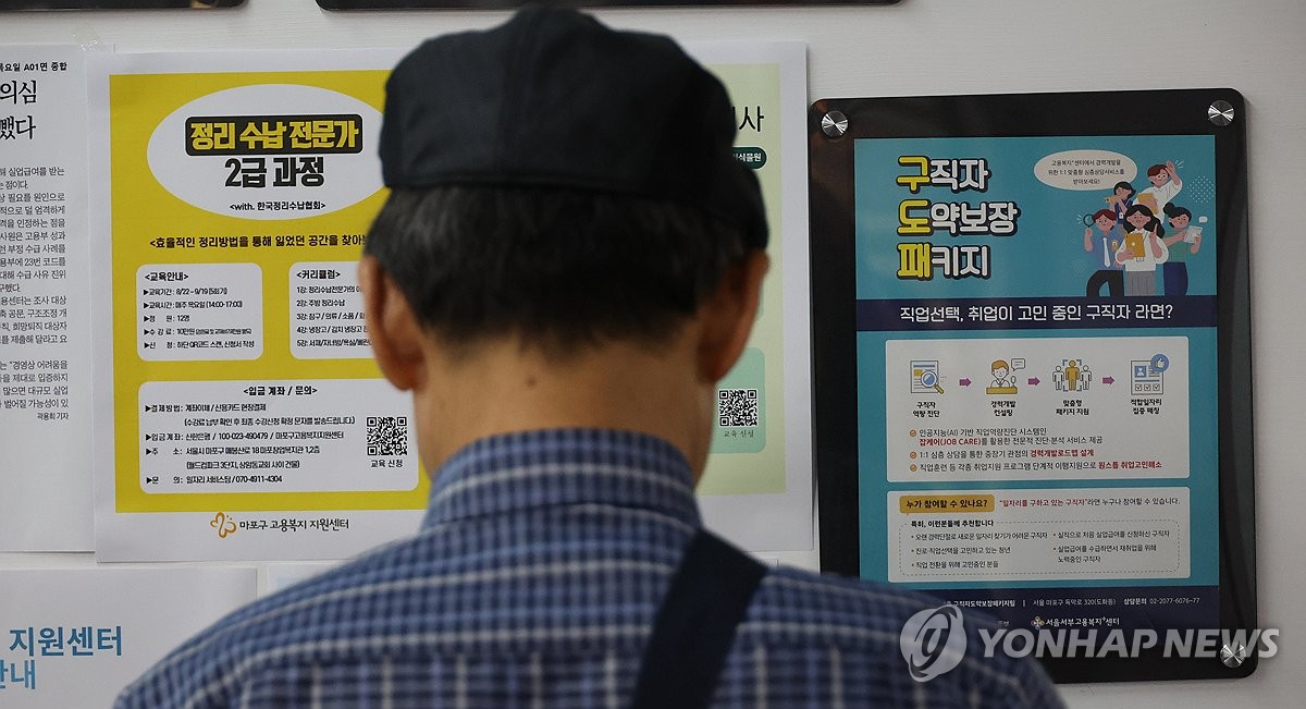 资料图片：求职者正在查看招聘信息。 韩联社