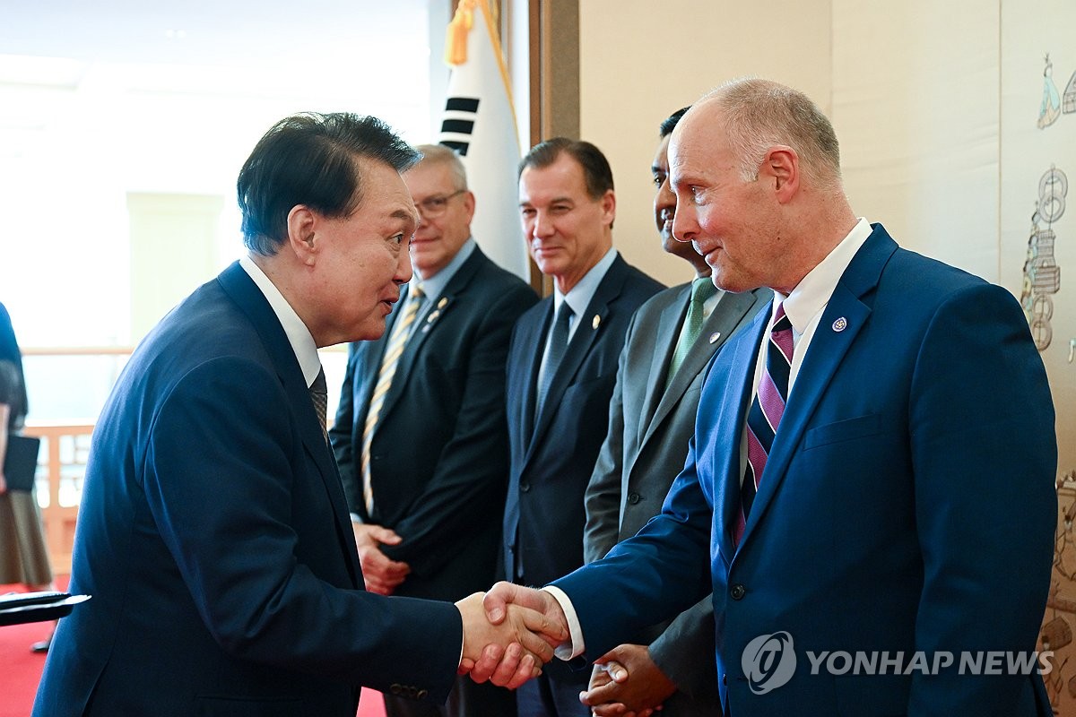 8月30日，在首尔龙山总统府，韩国总统尹锡悦（左）与美国众议院中国问题特别委员会主席约翰·穆勒纳尔握手致意。 韩联社/总统办公室供图（图片严禁转载复制）