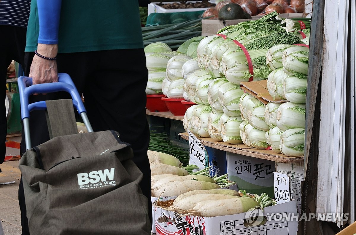 资料图片：一传统市场商铺前堆积着白菜。 韩联社